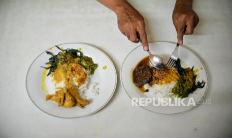 Konsumen menikmati menu masakan Padang di Rumah Makan Padang Surya Minang, Cikini, Jakarta.