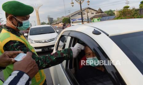 Petugas kesehatan TNI memeriksa suhu tubuh pengendara saat penyekatan dalam rangka larangan mudik di Kota Madiun, Jawa Timur, Selasa (4/5/2021). Penyekatan yang dilakukan petugas gabungan TNI, Polri, Satpol PP dan Badan Penanggulanan Bencana Daerah (BPBD) itu dimaksudkan untuk mengantisipasi pemudik masuk wilayah Kota Madiun guna mencegah penularan COVID-19. 