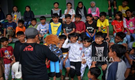 Anak mendengarkan cerita saat kegiatan trauma healing korban terdampak gempa di Taman Prawitasari, Kabupaten Cianjur, Jawa Barat, Ahad (27/11/2022). Kegiatan yang digelar Rappeling Education (RED) tersebut ditujukan untuk mengurangi trauma pada anak akibat gempa bumi. Republika/Thoudy Badai