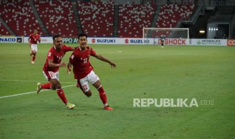 Winger timnas Indonesia Irfan Jaya (kiri) dan Pratama Arhan (kanan) merayakan gol ke gawang Malaysia dalam pertandingan Piala AFF 2021 di Stadion Nasional, Singapura, Ahad (19/12). Indonesia berhasil menang dengan skor 4-1 sekaligus menjadi juara grup dan maju ke babak semifinal,bertemu Singapura di semifinal pada Rabu (22/12) dan Sabtu (25/12)