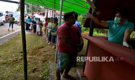 Hendak ke Kebun Raya, 14 Warga Gowa Dikarantina di Minahasa. Puluhan pelintas batas antre untuk diperiksa suhu tubuhnya di Pos Kesehatan di gerbang perbatasan Minahasa-MinahasaTenggara, Sulawesi Utara untuk mencegah penyebaran Covid-19..