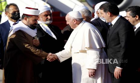  Paus Fransiskus, tengah, disambut oleh ulama Muslim saat ia tiba di bandara internasional Irbil, Irak, Minggu, 7 Maret 2021. Paus Fransiskus tiba di Irak utara pada hari Minggu, di mana ia berencana untuk berdoa di reruntuhan gereja yang rusak atau hancur. oleh ekstrimis Negara Islam dan merayakan Misa terbuka pada hari terakhir kunjungan paus pertama ke negara itu.