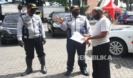 Petugas memberhentikan seorang pengguna jalan di cek poin Karanglo, Malang, Jawa Timur, Selasa (12/5/2020). Petugas mulai memperketat penyaringan atau screening para pengguna jalan menjelang pemberlakuan Pembatasan Sosial Berskala Besar (PSBB) di kawasan Malang Raya yang meliputi Kabupaten Malang, Kota Malang dan Kota Batu