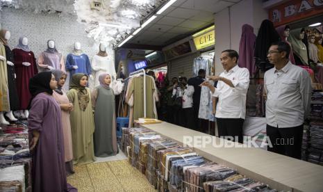 Presiden Joko Widodo (kedua kanan) didampingi Pj Gubernur DKI Jakarta Heru Budi Hartono (kanan) berdialog dengan para pedagang di Pasar Tanah Abang, Jakarta, Senin (2/1/2023). Aktivitas konsumsi masyarakat diprediksi akan meningkat setelah pemberlakuan pembatasan kegiatan masyarakat (PPKM) berhenti.