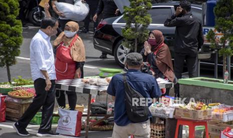 Presiden RI Joko Widodo menyapa pedagang saat kunjungan kerja di Pasar Sederhana, Sukajadi, Kota Bandung, Senin (17/1/2022). Dalam kunjungan tersebut Presiden RI Joko Widodo membagikan 2.000 paket sembako serta menyalurkan Bantuan Tunai untuk Pedagang Kaki Lima dan Warung (BT-PKLW) sebesar Rp1,2 juta kepada sedikitnya 100 pedagang di pasar tersebut. Foto: Republika/Abdan Syakura