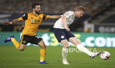  Kevin De Bruyne dari Manchester City, kanan, melakukan tembakan ke gawang saat Joao Moutinho dari Wolverhampton Wanderers menyaksikan pertandingan sepak bola Liga Premier Inggris antara Wolverhampton Wanderers dan Manchester City di Stadion Molineux di Wolverhampton, Inggris, Senin, 21 September 2020