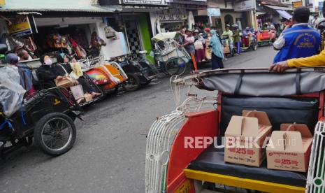 Deretan becak menunggu wisatawan berbelanja di sentra oleh-oleh di Yogyakarta. Geliat sentra oleh-oleh dipadati wisatawan. Dibukanya pintu pariwisata membuat roda ekonomi berputar kembali. Bakpia, batik, koas, dan pernak-pernik menjadi buruan wisatawan untuk buah tangan.