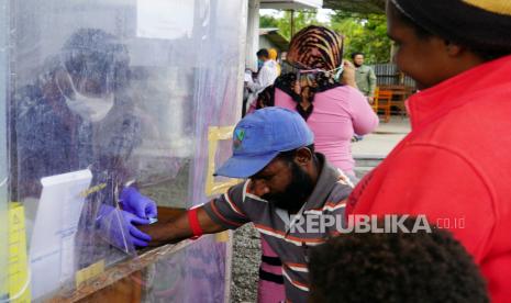 Seorang petugas melakukan tes cepat COVID-19 kepada warga di Puskesmas Wamena Kota, Wamena, Papua. 