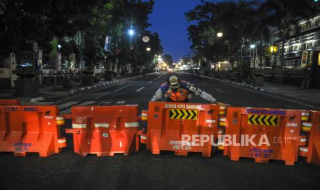 Petugas Dinas Perhubungan menutup Jalan Asia-Afrika di Bandung, Jawa Barat, Kamis (17/6/2021). Pemerintah Kota Bandung kembali menutup sejumlah ruas jalan protokol di Kota Bandung selama 14 hari kedepan dalam rangka pengetatan aktivitas masyarakat untuk menekan angka penyebaran COVID-19 di Kota Bandung. 