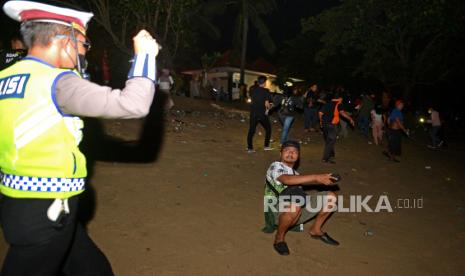 Polisi membubarkan warga yang masih melakukan aktivitas di luar rumah melebihi batas waktu yang ditentukan di Pantai Kuta, Badung, Bali, Sabtu (1/1/2022) dini hari. Petugas gabungan membubarkan aktivitas masyarakat di berbagai titik di kawasan wisata Kuta untuk mengantisipasi keramaian dan kerumunan masyarakat saat perayaan pergantian tahun baru. ANTARA FOTO/Fikri Yusuf/foc.