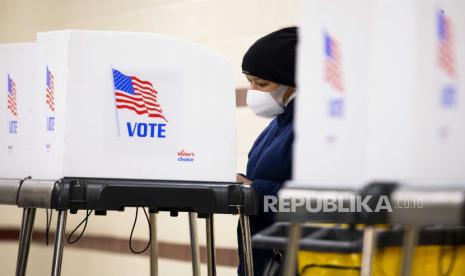  Seseorang berdiri di bilik pemungutan suara sambil bersiap untuk memberikan surat suara di lokasi pemungutan suara di dalam Show Place Arena di Upper Marlboro, Maryland, AS, 02 November 2020. Warga Amerika berpartisipasi dalam pemungutan suara awal menjelang Hari Pemilu untuk memilih antara pemilihan ulang Donald J. Trump atau memilih Joe Biden sebagai Presiden ke-46 Amerika Serikat untuk melayani dari tahun 2021 hingga 2024.