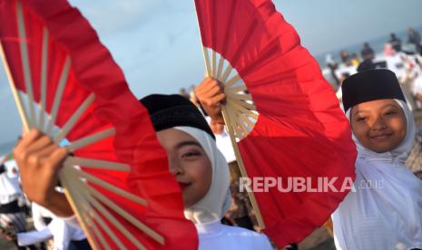 Pelajar menggunakan kipas untuk membawakan Tari Montro atau Kesenian Shalawat Montro di Pantai Parangtritis, Bantul, Yogyakarta, Sabtu (26/8/2023). Sekitar 10 ribu pelajar SMA sederajat menari Montro secara bersama untuk memecah rekor MURI penari terbanyak ketegori Tari Montro. Tari Montro perpaduan antara gending gamelan, shalawatan, serta tarian yang merupakan warisan budaya tak benda milik Kabupaten Bantul. Tari ini diciptakan oleh KP Yudhonegoro yang merupakan menantu Sri Sultan Hamengku Buwono VIII di Pleret untuk sarana dakwah dalam rangka Maulid Nabi Muhammad.