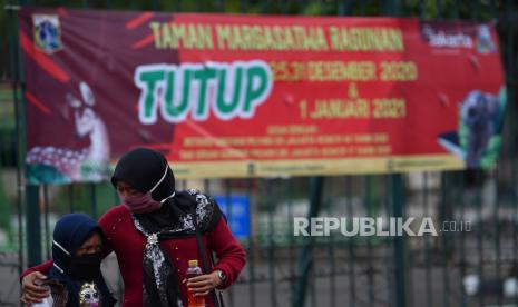 Warga meninggalkan Taman Margasatwa Ragunan yang tutup di Jakarta Selatan, Jumat (25/12/2020). Pemerintah Provinsi DKI Jakarta menutup area publik dan sejumlah tempat wisata termasuk Taman Margasatwa Ragunan selama masa libur perayaan Hari Natal dan Tahun Baru pada 25 dan 31 Desember 2020, serta 1 Januari 2021. 