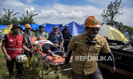 Relawan mengevakuasi warga yang sakit di area tenda pengungsian di Perkebunan Gedeh, Sukamulya, Kecamatan Cugenang, Kabupaten Cianjur, Rabu (23/11/2022). Berdasarkan data dari BPBD Provinsi Jawa Barat per Rabu (23/11/2022) pukul 09.00 WIB, jumlah pengungsi akibat gempa bumi 5,6 SR di Kabupaten Cianjur mencapai 58.362 orang. Republika/Abdan Syakura