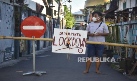 Seorang laki-laki menggunakan masker berada di gerbang yang ditutup untuk antisipasi penyebaran COVID-19, ilustrasi. Pemkab Lombok Utara mulai membuka kembali tempat ibadah dan pasar. 