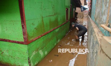 Warga membersihkan rumahnya yang dipenuhi lumpur akibat banjir bandang (Ilustrasi)