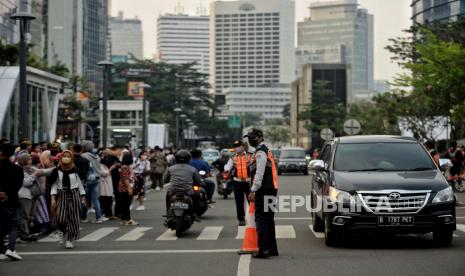 Petugas Dinas Perhubungan (Dishub) mengatur lalu lintas di area zebra cross yang dijadikan lokasi peragaan busana Citayam Fashion Week di kawasan Dukuh Atas, Jakarta, Rabu (27/7/2022). Sejumlah petugas gabungan dari Dishub dan Satpol PP melakukan penjagaan dan normalisasi fungsi zebra cross untuk penyeberangan serta perlintasan kendaraan motordan mobil. Meski demikian, kegiatan fashion show jalanan tersebut masih tetap berlangsung dengan imbauan untuk menjaga ketertiban agar tidak terjadi kemacetan. Republika/Thoudy Badai