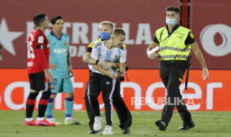 Penggemar Lionel Messi masuk ke lapangan saat laga antara Mallorca vs Barcelona di Stadion Son Moix, Mallorca.