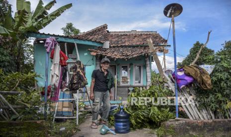 Warga berada di depan rumahnya yang rusak pasca gempa bumi di Kampung Selakawung, Kecamatan Cilaku, Kabupaten Cianjur, Selasa (22/11/2022). Berdasarkan data dari BPBD Kabupaten Cianjur hingga Senin (21/11/2022) pukul 20.00 WIB jumlah bangunan dan rumah rusak akibat gempa bumi mencapai 2.345 unit serta 13.784 orang mengungsi. 