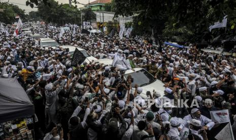 Imam Besar Front Pembela Islam (FPI) Habib Rizieq Shihab menyapa massa saat tiba di kawasan Petamburan, Jakarta. RIbuan simpatisan HRS yang menyambut itu akhir membuat sejumlah pengguna jalan raya terhalang ke tempat tujuannya. Salah satunuya, ada seorang pasien cuci darah yang terpakaksa turun dan berjalan kaki menuju RS Pelni. 