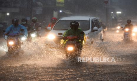 Pengendara melintasi genangan air yang menutupi ruas jalan di kawasan Mampang Prapatan, Jakarta, Ahad (19/9). Perubahan iklim dapat memicu terjadinya cuaca ekstrem yang menyebabkan banjir dan kekeringan intens.