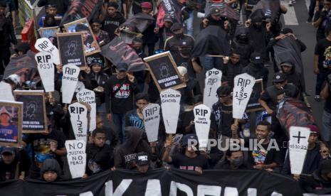  Pendukung sepak bola memegang plakat dan gambar korban penyerbuan stadion Kanjuruhan saat mereka berbaris menuju balai kota di Malang, Kamis (10/11/2022). Lebih dari seribu pengunjuk rasa menggelar unjuk rasa menuntut penyelidikan yang adil menyusul penyerbuan stadion Kanjuruhan pada 01 Oktober 2022 yang menyebabkan 135 orang tewas dan ratusan lainnya luka-luka.