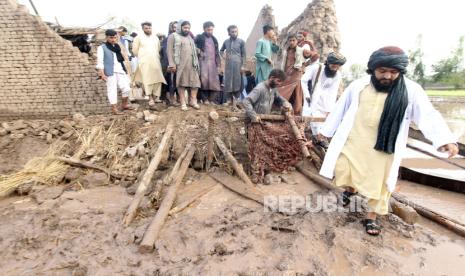  Orang-orang membersihkan puing-puing rumah yang rusak akibat tanah longsor dan hujan deras di distrik Surkhroad Jalalabad, Nangarhar, Afghanistan, Senin (15/7/2024). 