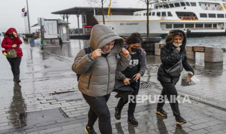 Pemuda Uighur Berjuang Melawan Kemiskinan di Jalanan Istanbul. Orang-orang berlarian di bawah hujan lebat selama hari badai di Istanbul, Turki, Senin, 29 November 2021. Badai kuat melanda Istanbul dan bagian lain Turki pada hari Senin, menewaskan sedikitnya empat orang dan menyebabkan kekacauan di kota berpenduduk 15 juta jiwa. orang, kata laporan.