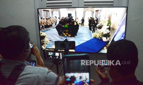 Awak media dan warga menyaksikan suasana di dalam gedung melalui layar monitor saat kedatangan jenazah Emmeril Kahn Mumtadz atau Eril di rumah dinas Gubernur Jawa Barat Gedung Pakuan, Kota Bandung, Ahad (12/6). Pemakaman Eril akan akan dilaksanakan Senin (13/6) pagi, di Cimaung, Kabupaten Bandung.