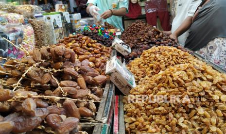 Pedagang kurma melayani pembeli di Pasar Baru, Kota Bandung, Jawa Barat, Senin (18/3/2024).