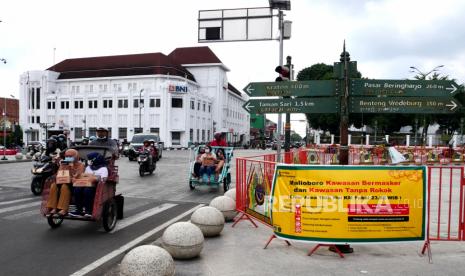 Wisatawan berjalan-jalan dengan becak di kawasan Titik Nol Yogyakarta, Selasa (19/10). 