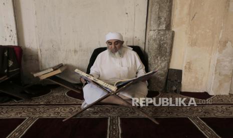 Seorang pria membaca Alquran di hari pertama bulan puasa Ramadhan di sebuah masjid di Sanaa, Yaman,Kamis (23/3/2023). Tantangan Puasa di Berbagai Belahan Dunia: Durasi 21 Jam Hingga Tantangan Suhu Ekstrem