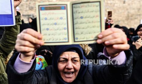 Seorang demonstran wanita memegang Alquran saat melakukan protes di depan Konsulat Jenderal Swedia, di Istanbul, Turki, 22 Januari 2023. Demonstran berkumpul setelah politikus sayap kanan Swedia-Denmark Rasmus Paludan diizinkan menggelar demonstrasi dan membakar salinan Alquran di depan kedutaan Turki di Stockholm pada 21 Januari 2023. Alquran Dibakar di Swedia, Begini Respons Kemenag