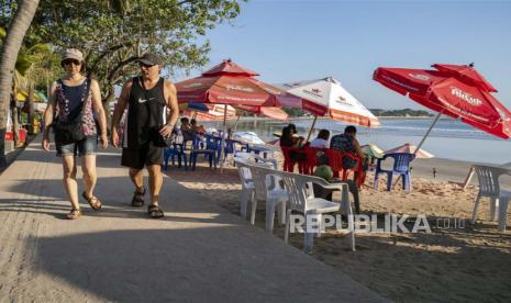  Wisman berjalan-jalan di pantai Kuta, Bali, Senin (22/5/2023).