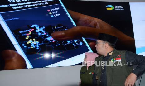 Gubernur Jawa Barat Ridwan Kamil (kanan) bersama Ketua Jabar Bergerak Atalia Praratya mengamati content aplikasi Pusat Informasi dan Koordinasi COVID-19 (Pikobar) usai peluncuran aplikasi tersebut di Jabar Command Center, kompleks Gedung Sate, Kota Bandung, Jumat (20/3). Aplikasi Pikobar diharapkan dapat memberikan layanan dan informasi terkait perkembangan wabah Corona atau Covid-19 kepada masyarakat dengan mudah.