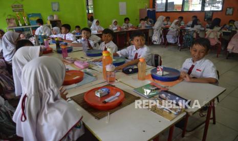 Para siswa bersiap menikmati makanan saat uji coba pelaksanaan program Makan Bergizi Gratis (MBG) di SDN 4  Kota Tangerang, Banten, Senin (5/8/2024). Uji coba MBG tersebut bertujuan mematangkan strategi dan mitigasi program unggulan Presiden dan Wakil Presiden Terpilih periode 2024-2029. Adapun paket menu yang disediakan hari ini adalah Nasi Putih, Fuyunghai, Capcay, Melon dan Susu.