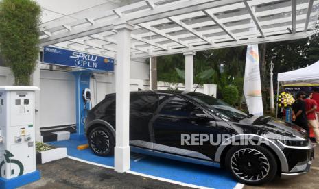 Pengunjung berdiri disamping kendaraan listrik yang sedang mengisi daya di SPKLU di Balai Kota Bogor, Jawa Barat (ilustrasi). Gabungan Industri Kendaraan Bermotor Indonesia (Gaikindo) menilai target produksi sejuta mobil listrik (electric vehicle/ EV) pada 2035 akan cukup menantang dicapai meski pemerintah telah mengumumkan soal insentif pembelian kendaraan listrik.