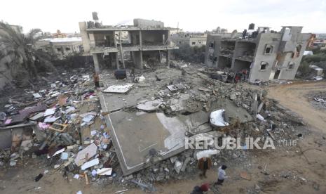 Palestinians look at houses destroyed in the Israeli bombardment of the Gaza Strip in Rafah on Monday, Nov. 20, 2023.