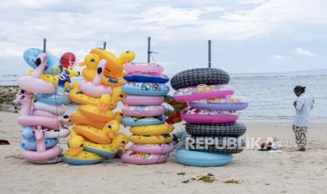 Seorang pria yang menjual dan menyewakan mainan pantai tiup menunggu pelanggan di kawasan wisata di Sanur, Bali, Indonesia, 18 Februari 2022. Denpasar Siapkan Rp 28 miliar Tata Pantai Sanur 