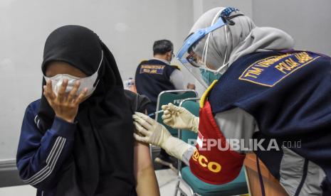 Vaksinator menyuntikkan vaksin Covid-19 ke mahasiswa saat Program Vaksinasi Covid-19 Mahasiswa di Kampus Telkom University, Kabupaten Bandung, Senin (21/6). Program vaksinasi yang digelar oleh Polda Jabar dan alumni FK Unpad bekerja sama dengan Telkom University tersebut menyediakan sebanyak 3.000 dosis vaksin Covid-19 yang ditujukan bagi mahasiswa dan pegawai kampus sebagai upaya percepatan program vaksinasi nasional. 