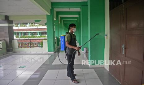 Petugas menyemprotkan disinfektan di SMPN 252, Jakarta yang tengah mengehentikan sementara kegiatan PTM (Pembelajaran Tatap Muka) setelah terdapat satu siswa yang positif COVID-19, Jumat (14/1/2022). Pemprov DKI Jakarta tetap akan menggelar Pembelajaran Tatap Muka (PTM) 100 persen, walau saat ini sudah ada beberapa sekolah yang ditutup sementara akibat ditemukannya kasus covid saat PTM berlangsung.Prayogi/RepublikA