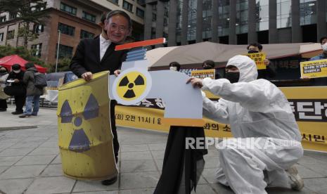 Seorang aktivis lingkungan yang mengenakan topeng Perdana Menteri Jepang Yoshihide Suga tampil untuk mengecam keputusan pemerintah Jepang tentang air Fukushima, dekat kedutaan Jepang di Seoul, Korea Selatan, Selasa, 13 April 2021. Pemerintah Jepang memutuskan Selasa untuk mulai melepaskan sejumlah besar mengolah air radioaktif dari pembangkit nuklir Fukushima yang hancur ke Samudera Pasifik dalam dua tahun - sebuah pilihan yang ditentang keras oleh nelayan dan penduduk setempat.