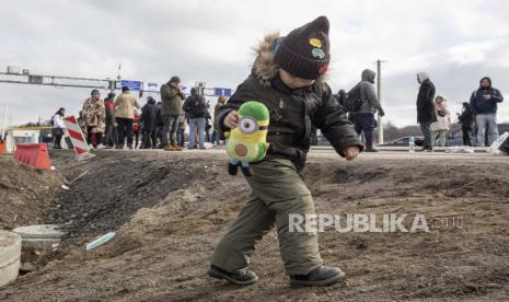 Seorang anak pengungsi yang melarikan diri dari konflik di Ukraina memegang mainan yang diberikan kepadanya setelah tiba di perbatasan Medyka di Polandia, Senin, 28 Februari 2022. 