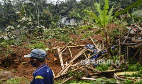 Warga melihat material tanah longsor yang menimbun jalan dan rumah di Kampung Cikidang, Desa Kawitan, Kecamatan Salopa, Kabupaten Tasikmalaya, Jawa Barat, Senin (12/10/2020). Curah hujan yang tinggi di Tasikmalaya mengakibatkan satu pabrik kayu dan satu rumah serta jalur alternatif selatan tertimbun tanah longsor sehingga tidak bisa dilalui kendaraan. 