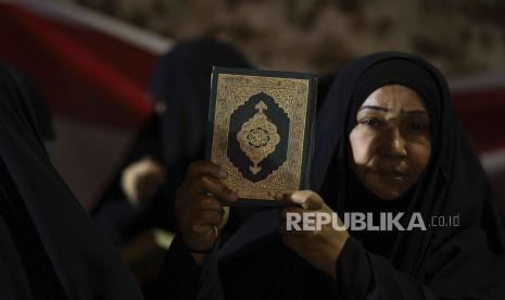 Pendukung ulama Muqtada al-Sadr mengangkat Alquran dalam aksi massa di Sadr City, Irak, 12 Juli 2023.