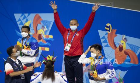 Gubernur DKI Jakarta Anies Baswedan (kiri) menyaksikan pemberian medali kepada atlet renang putra DKI Jakarta Joe Aditya W Kurniawan (tengah) seusai memenangkan final Renang 200 meter Gaya Bebas Putra PON Papua di Stadion Akuatik, Kampung Harapan, Kabupaten Jayapura, Papua, Senin (11/10/2021). Joe Aditya W Kurniawan berhasil meraih medali emas dengan catatan waktu 1 menit 51.05 detik sedangkan perak diraih Aflah Fadlan (Jabar) dengan catatan waktu 1 menit 51.39 detik dan perunggu diraih Erick Ahmad Fathoni (Jabar) dengan catatan waktu 1 menit 53.11 detik. 