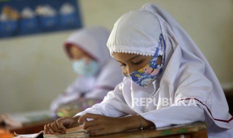 Siswa sekolah dasar mengikuti pelajaran memakai masker (ilustrasi).