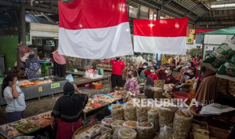 Pedagang memberi hormat kepada bendera merah putih pada Peringatan HUT Kemerdekaan ke-76 Republik Indonesia di Pasar Gede, Solo, Jawa Tengah, Selasa (17/8/2021). Aksi hormat bendera tersebut untuk menumbuhkan semangat nasionalisme dan cinta tanah air. 