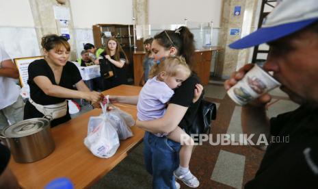 Pengungsi dari Mykolayiv menerima bantuan makanan kemanusiaan saat mereka menunggu di stasiun kereta api di Odesa, Ukraina barat daya, 02 Juni 2022, sebelum melakukan perjalanan ke barat Ukraina atau negara lain. Pihak berwenang Mykolayiv meminta penduduk setempat untuk meninggalkan beberapa wilayah kota di tengah invasi Rusia. 