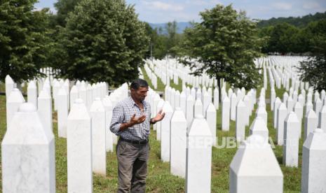 Penyintas Cari Tulang Muslim Korban Pembantaian Srebrenica. Penyintas pembantaian Srebrenica Ramiz Nukic berdoa dekat makam ayah dan dua saudaranya di Pemakaman Srebrenica-Potocari Memorial Center dekat Srebrenica, Bosnia dan Herzegovina, 6 Juli 2020. 